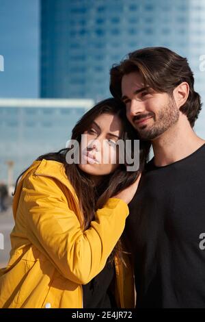 Smiling young couple looking away on sunny day Stock Photo