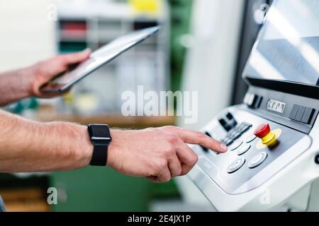 Male engineer with digital tablet operating machinery equipment in industry Stock Photo