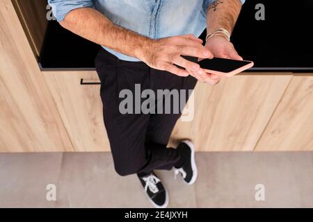 Mature man using smart phone at home Stock Photo