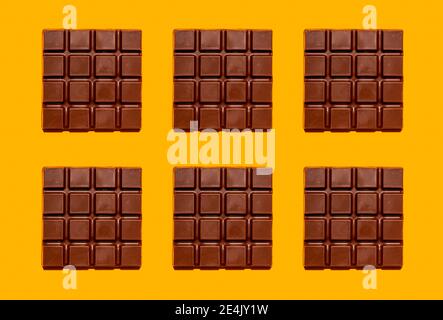 Pattern of chocolate bars against yellow background Stock Photo