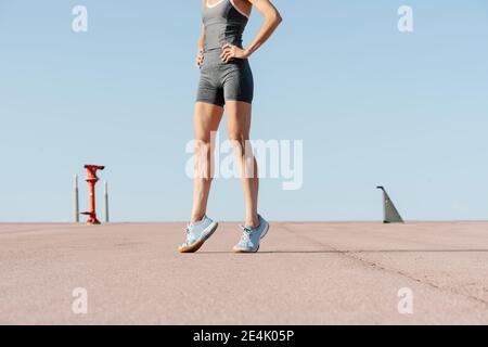 Female sportsperson with hand on hip standing on tiptoe Stock Photo