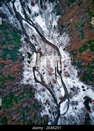 Aerial view of river flowing through snow-covered landscape Stock Photo