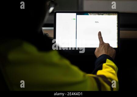 Mature technician using digital tablet for programming in car Stock Photo