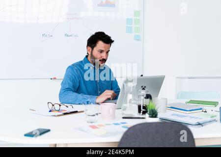 Man using laptop in office Stock Photo