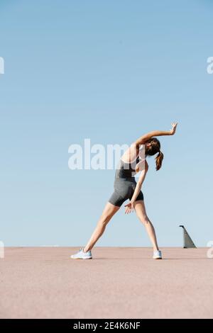Elegant sportswoman practicing yoga on a sunny day Stock Photo