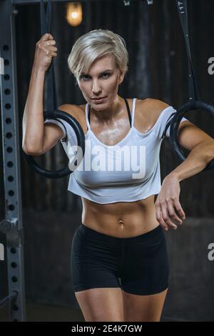 athlete blond woman wearing black closes listening music in earphones and  working out on running track Stock Photo - Alamy