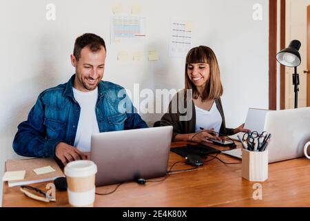 Smiling business couple working together from home in living room Stock Photo