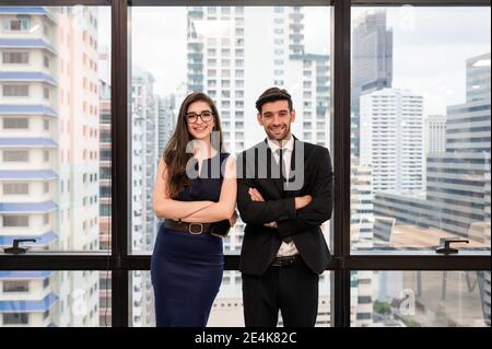 Attractive young caucasian business partner standing crossed arm with smiling and looking at camera in modern office at downtown Stock Photo