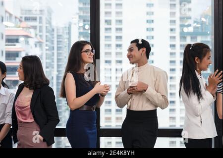 Multiethnic business meeting of colleague standing discussing on side window in modern office Stock Photo