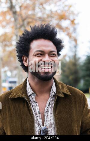 Close-up of mid adult man with afro hair laughing while looking away Stock Photo