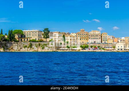 Buildings by sea against blue sky during sunny day, Corfu Town, Greece Stock Photo