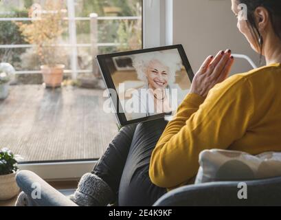 Two women talking during video call on digital tablet Stock Photo