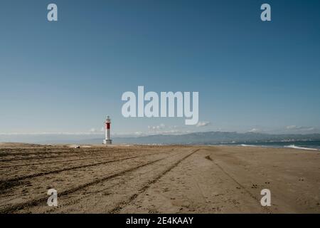 Clear sky over empty Platja del Fangar beach with Far del Fangar lighthouse in background Stock Photo