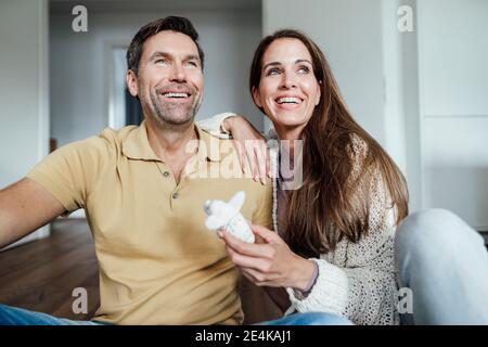 Happy couple with stuffed elephant toy looking away at home Stock Photo