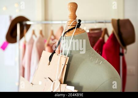 Cardboards hanging on dressmaker's model with straight pins at design studio Stock Photo