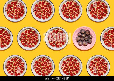 Pattern of plates with fresh halved figs Stock Photo