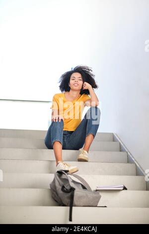 Young student sitting on steps at university Stock Photo