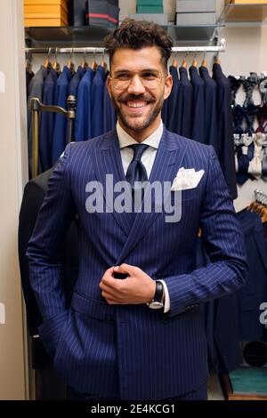 Portrait of smiling man in blue pinstripe suit in tailors boutique Stock Photo