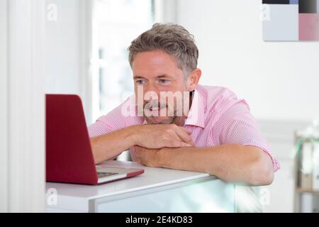 Mature male professional using laptop at desk Stock Photo