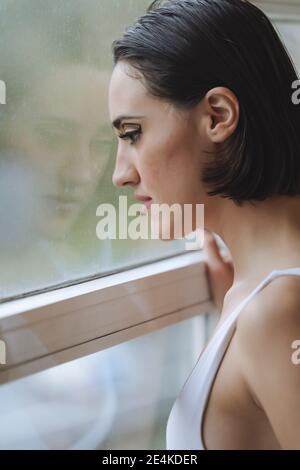 Close-up of thoughtful young woman looking through window in ballet studio Stock Photo
