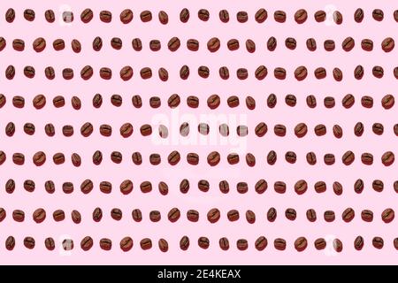 Pattern of roasted coffee beans against pink background Stock Photo