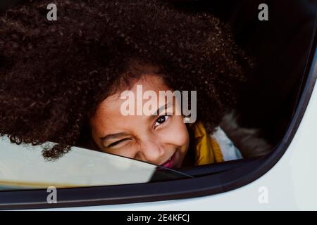 Close-up portrait of girl winking eye in car Stock Photo