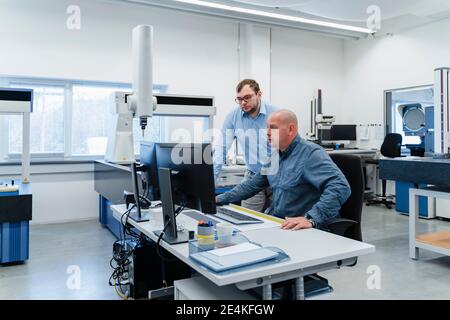 Engineers using computer while working together at office Stock Photo