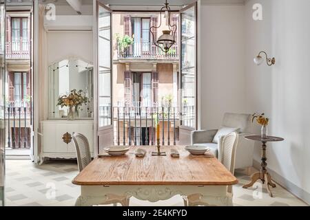 Wooden dining table served for two persons in classic living room decorated in retro style. Stock Photo