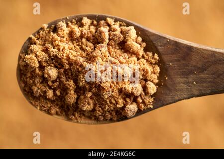 Rapadura or panela - healthy sweetener made by evaporating sugercane juice, on a wooden spoon, top view Stock Photo