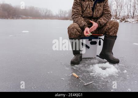 Premium Photo  The guy on the winter fishing at the hole catches