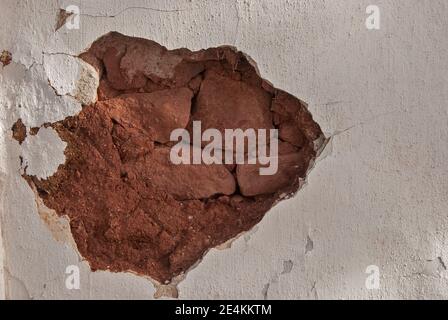 Fallen piece of plaster on old country house wall Stock Photo