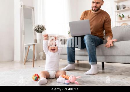 Little Baby Toddler Playing Bothering Displeased Father Freelancer At Home Stock Photo