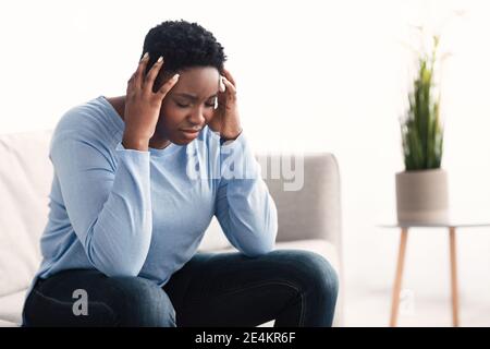 Black woman touching her head feeling stress Stock Photo