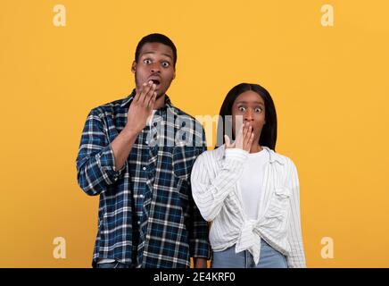 Shocking news, unexpected events. Surprised scared millennial african american female and man with wide open eyes Stock Photo