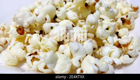 Heap of delicious popcorn, isolated on white background. Scattered popcorn texture background Stock Photo