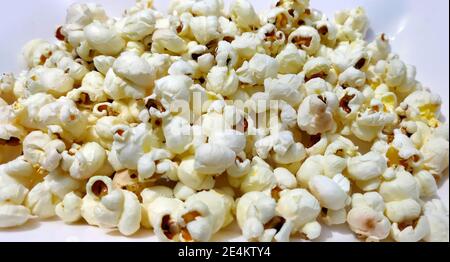 Heap of delicious popcorn, isolated on white background. Scattered popcorn texture background Stock Photo