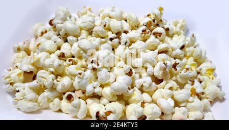 Heap of delicious popcorn, isolated on white background. Scattered popcorn texture background Stock Photo