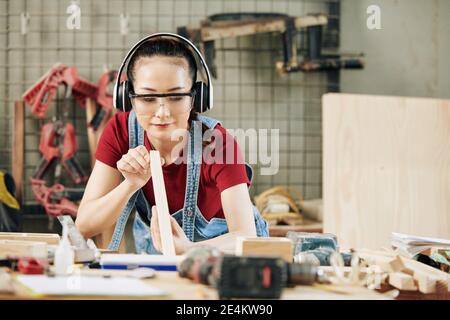 Carpenter checking plank evenness Stock Photo