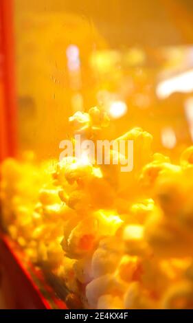 Cape Town  South Africa- 01-01-2020 Tasty buttery popcorn, grouped together in red popcorn machine. Gives a warm wholesome feeling. Stock Photo