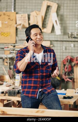 Carpenter talking on phone with customer Stock Photo