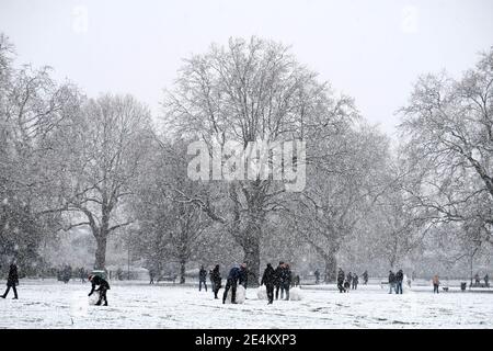 Kennington Park, London, UK. 24th January 2021. Crowds of people play in the snow in Kennington Park, London, UK, as group of friends are building snowman. Credit: Harrison Hodgkins/Alamy Live News. Stock Photo