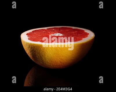 Half a grapefruit close-up on a black background. Stock Photo