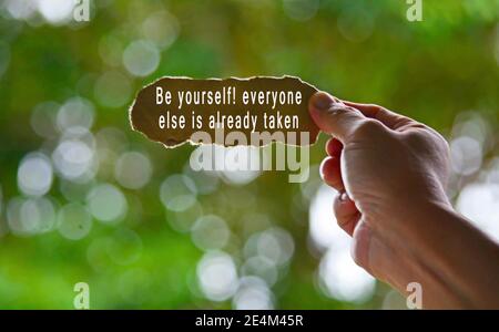 Text Written On Hand Holding Torn Paper With Blurred Green Background Stock Photo