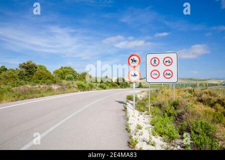 sign showing prohibited vehicles symbols (pedestrian, tractor, caravan, bike, moped, horse) before drive on the highway in lonely road of Spain, Europ Stock Photo