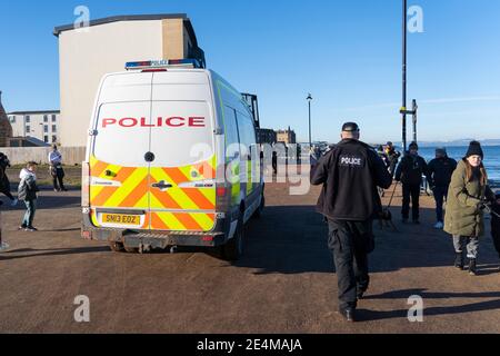 Portobello, Scotland, UK. 24 January 2021. Large numbers of members of the public at Portobello beach and promenade on sunny Sunday afternoon during lockdown. While most people observed social distancing groups of people formed at some of the cafes offering takeaway food and drinks. Police patrols spoke to public sitting down and in groups at cafes to ask them to move on. Iain Masterton/Alamy Live News Stock Photo