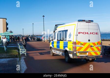 Portobello, Scotland, UK. 24 January 2021. Large numbers of members of the public at Portobello beach and promenade on sunny Sunday afternoon during lockdown. While most people observed social distancing groups of people formed at some of the cafes offering takeaway food and drinks. Police patrols spoke to public sitting down and in groups at cafes to ask them to move on. Iain Masterton/Alamy Live News Stock Photo