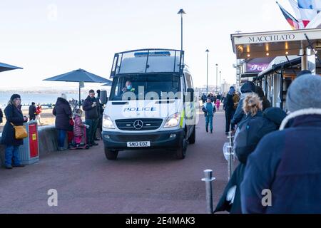 Portobello, Scotland, UK. 24 January 2021. Large numbers of members of the public at Portobello beach and promenade on sunny Sunday afternoon during lockdown. While most people observed social distancing groups of people formed at some of the cafes offering takeaway food and drinks. Police patrols spoke to public sitting down and in groups at cafes to ask them to move on. Iain Masterton/Alamy Live News Stock Photo