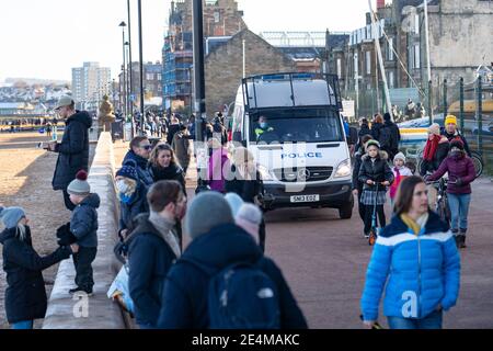 Portobello, Scotland, UK. 24 January 2021. Large numbers of members of the public at Portobello beach and promenade on sunny Sunday afternoon during lockdown. While most people observed social distancing groups of people formed at some of the cafes offering takeaway food and drinks. Police patrols spoke to public sitting down and in groups at cafes to ask them to move on. Iain Masterton/Alamy Live News Stock Photo