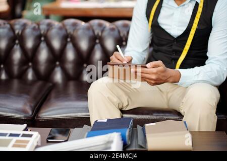 Cropped image of tailor using digital pen when drawing fashion sketch on tablet computer Stock Photo