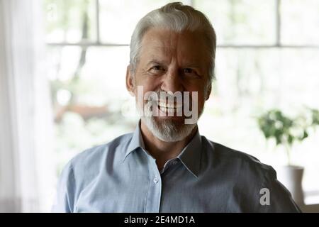 Close up laughing elderly grey haired man looking at camera Stock Photo